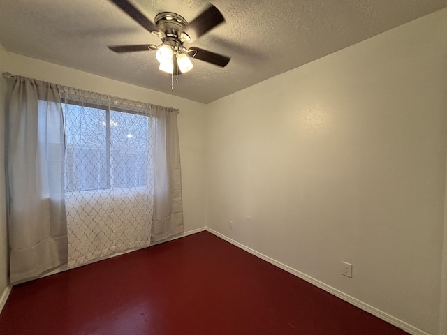 unfurnished room featuring a textured ceiling, ceiling fan, and baseboards