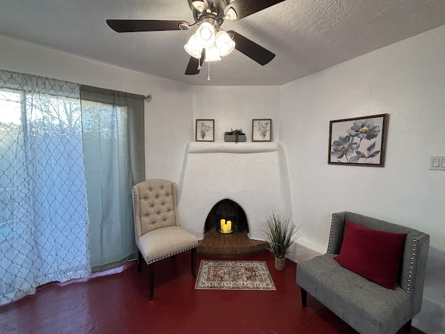 living area featuring a textured ceiling and a ceiling fan