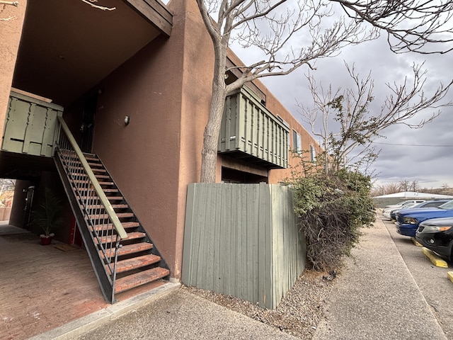 view of side of home featuring stucco siding and stairs