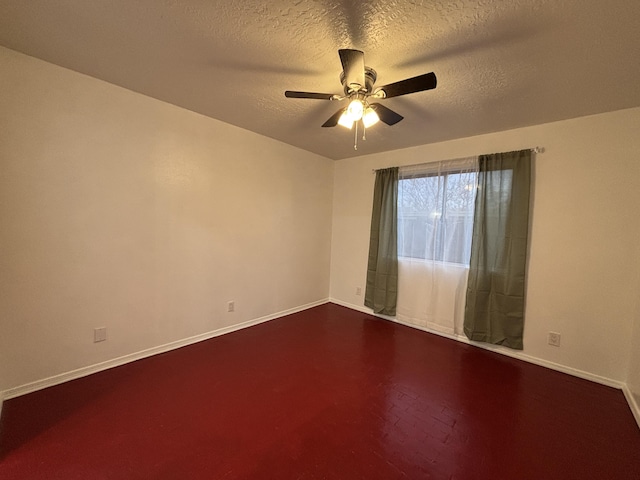 unfurnished room featuring a ceiling fan, a textured ceiling, and baseboards