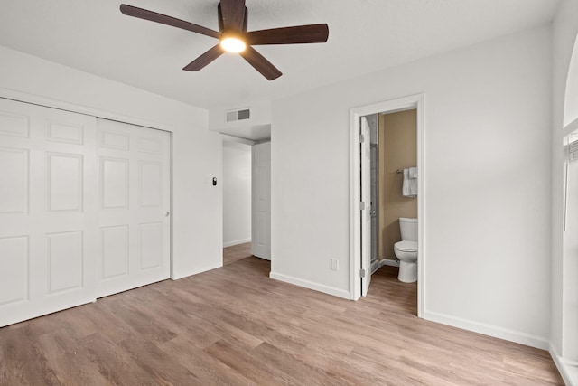 unfurnished bedroom with ceiling fan, connected bathroom, a closet, and light hardwood / wood-style flooring