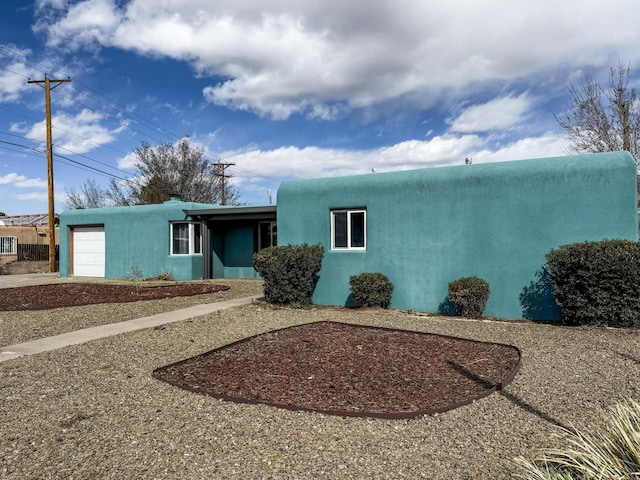 view of front facade with a garage and stucco siding