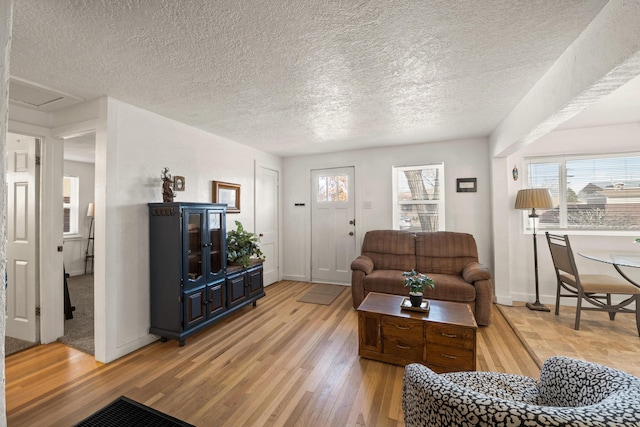 living room featuring light hardwood / wood-style floors and a textured ceiling