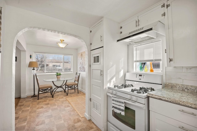 kitchen with white cabinets, plenty of natural light, and white gas stove