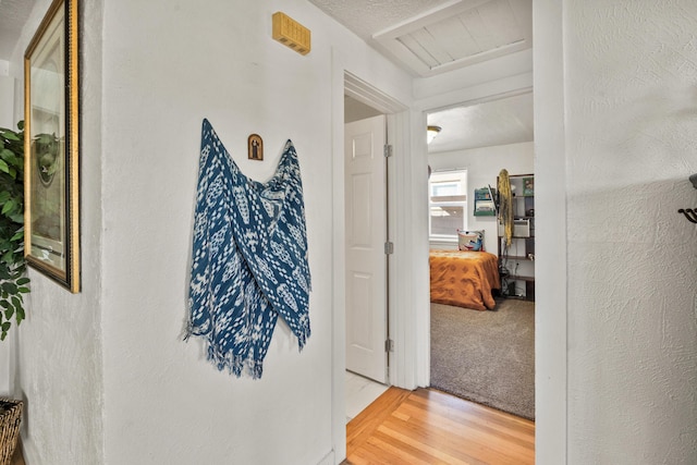 corridor featuring wood-type flooring and a textured ceiling