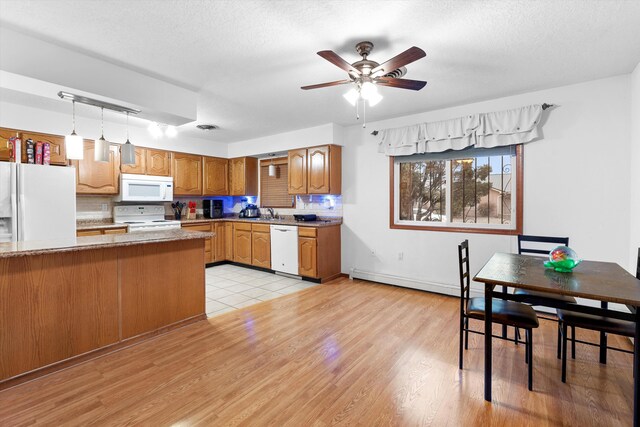 kitchen featuring decorative backsplash, white appliances, a baseboard radiator, and hanging light fixtures