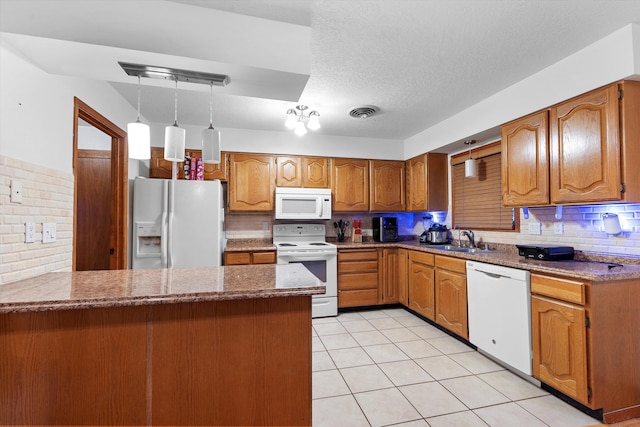 kitchen with sink, backsplash, white appliances, and kitchen peninsula