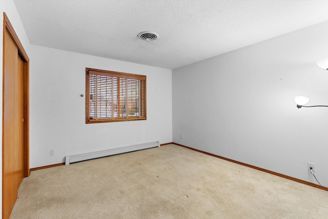 unfurnished bedroom with a baseboard heating unit, light colored carpet, a closet, and a textured ceiling