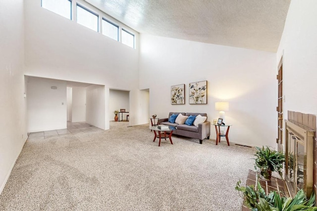 living room with light colored carpet, a textured ceiling, and a high ceiling