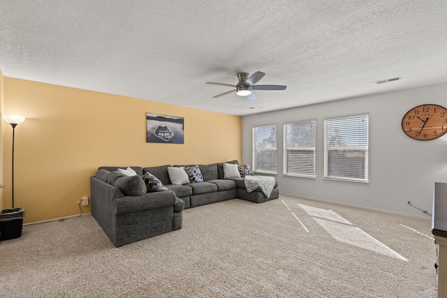 carpeted living room with a textured ceiling and ceiling fan