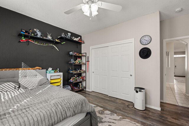 bedroom featuring ceiling fan, dark hardwood / wood-style flooring, and a closet