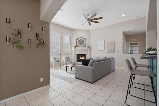 tiled living room featuring a tile fireplace and ceiling fan