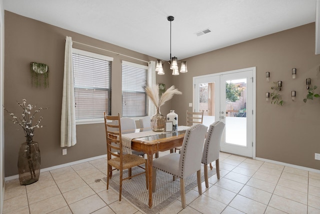 dining room featuring french doors, a chandelier, and light tile patterned floors