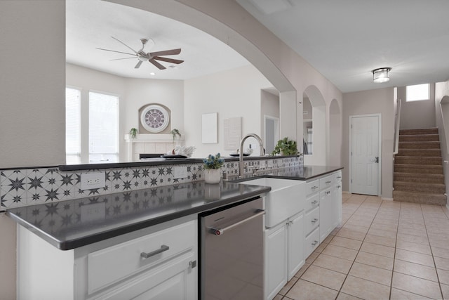 kitchen with light tile patterned floors, dishwasher, sink, and white cabinets