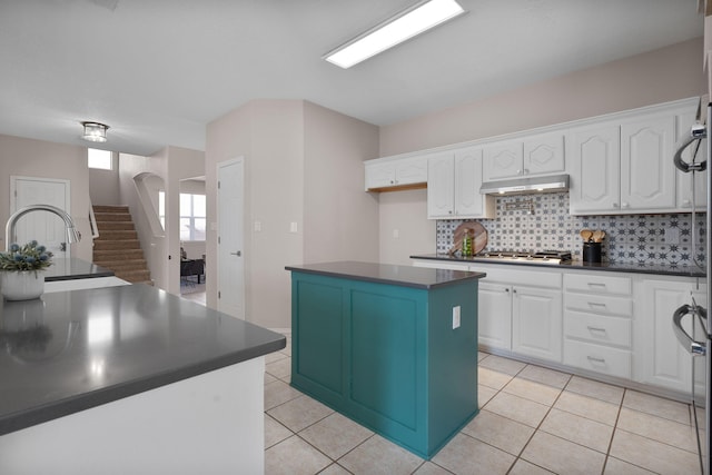 kitchen featuring white cabinetry, a kitchen island, stainless steel gas cooktop, and light tile patterned floors