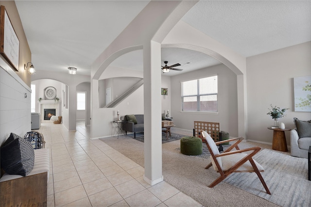 tiled living room featuring ceiling fan and a textured ceiling