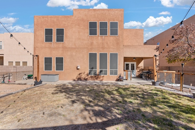 rear view of house featuring a patio area, french doors, and a lawn