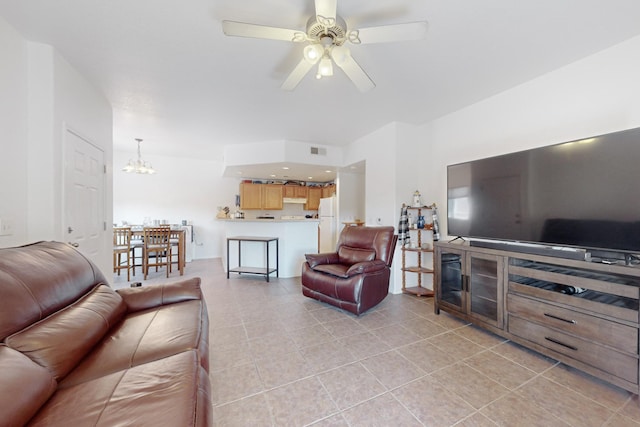 tiled living room with ceiling fan with notable chandelier