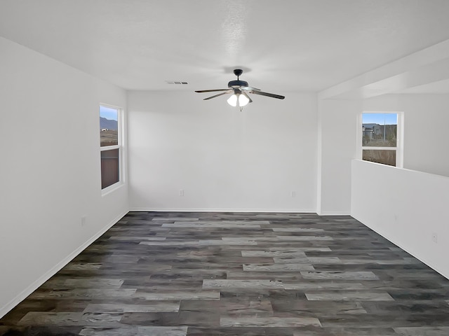 unfurnished room with ceiling fan, dark hardwood / wood-style floors, and plenty of natural light