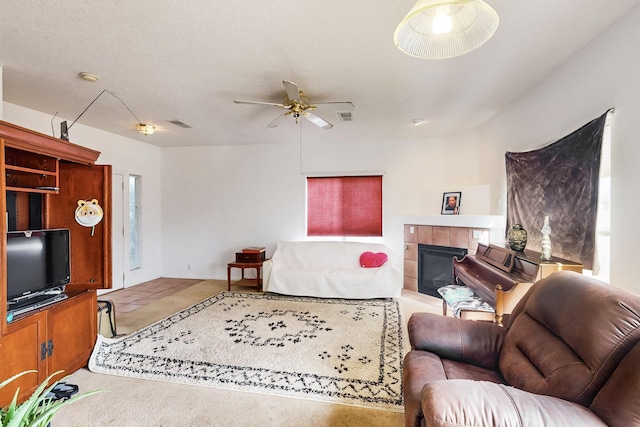 living room featuring a tile fireplace and ceiling fan