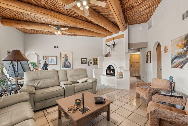 8008 Loma Larga Rd, Corrales, NM 87048 - living room with a ceiling fan, light tile patterned flooring, wood ceiling with exposed beams, arched walkways, and a glass covered fireplace