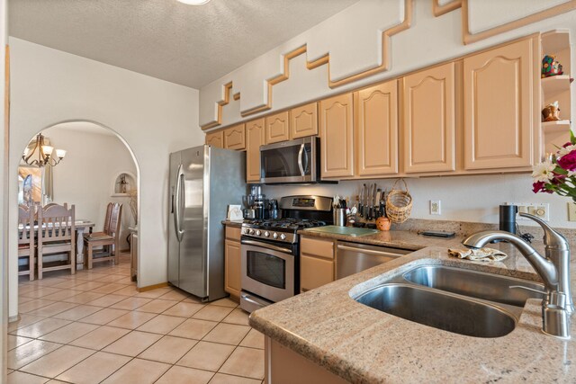 8008 Loma Larga Rd, Corrales, NM 87048 - kitchen featuring appliances with stainless steel finishes, a sink, light tile patterned floors, light brown cabinets, and a chandelier