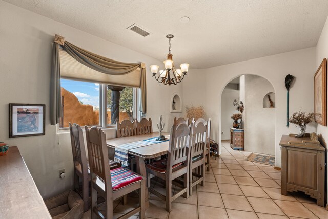 8008 Loma Larga Rd, Corrales, NM 87048 - dining room featuring arched walkways, a chandelier, and light tile patterned floors