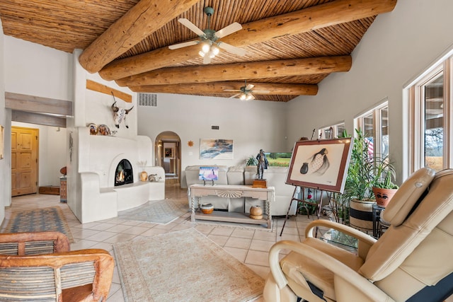 8008 Loma Larga Rd, Corrales, NM 87048 - tiled living room featuring a ceiling fan, arched walkways, wood ceiling with exposed beams, and a fireplace