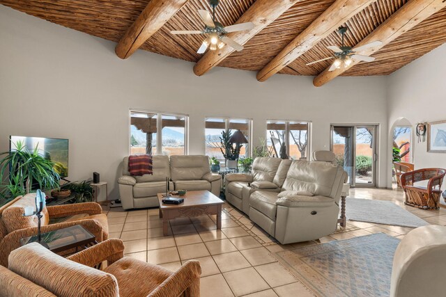 8008 Loma Larga Rd, Corrales, NM 87048 - living room with light tile patterned floors, a ceiling fan, wooden ceiling with exposed beams, a towering ceiling, and arched walkways
