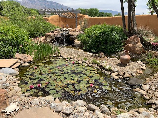 8008 Loma Larga Rd, Corrales, NM 87048 - view of yard with a garden pond and a mountain view
