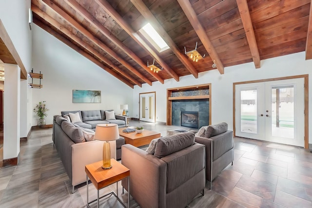 living room featuring beamed ceiling, french doors, a skylight, baseboards, and wood ceiling