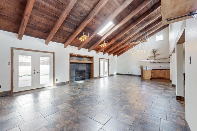 unfurnished living room featuring wooden ceiling, french doors, baseboards, and beam ceiling
