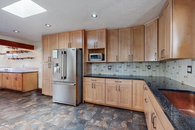 kitchen with open shelves, a skylight, stainless steel appliances, stone finish floor, and backsplash