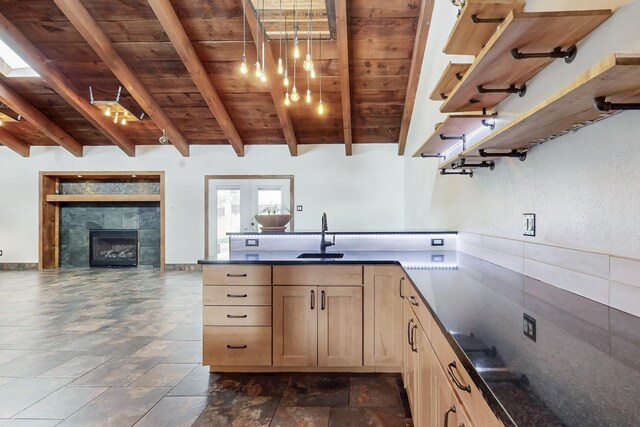 kitchen with dark countertops, beam ceiling, wood ceiling, and a sink