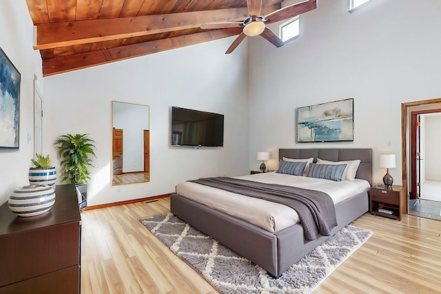 bedroom with beamed ceiling, high vaulted ceiling, light wood-style floors, wood ceiling, and ceiling fan