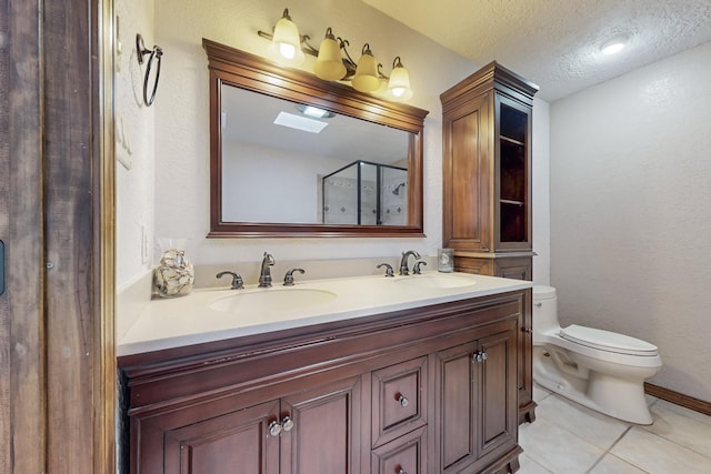 full bathroom with a sink, toilet, a textured ceiling, and tile patterned flooring