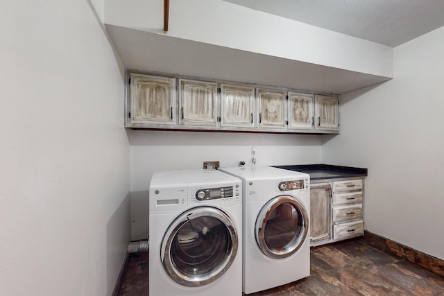 laundry room with cabinet space, washer and dryer, baseboards, and stone finish floor