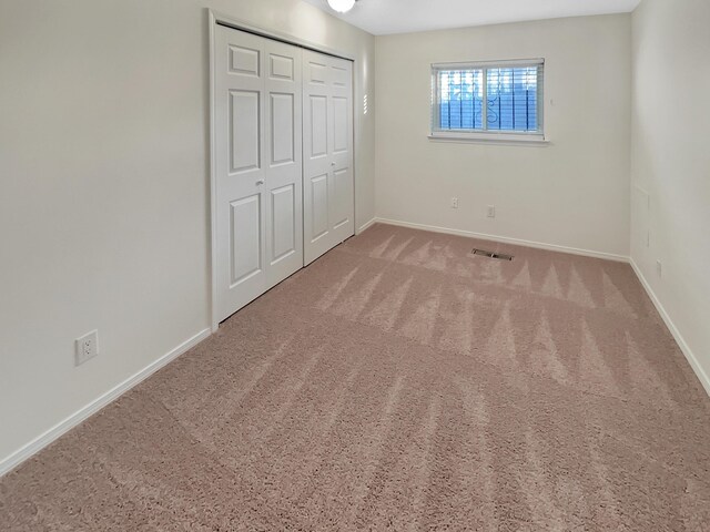 unfurnished bedroom featuring carpet and a closet