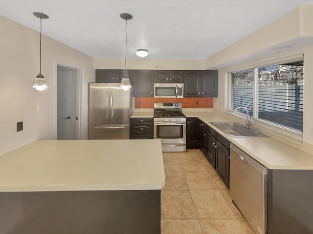 kitchen featuring sink, appliances with stainless steel finishes, light tile patterned flooring, and decorative light fixtures