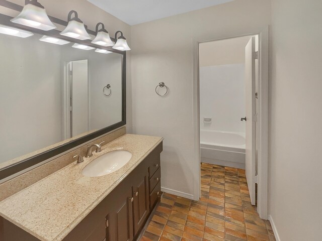 bathroom featuring vanity and a washtub