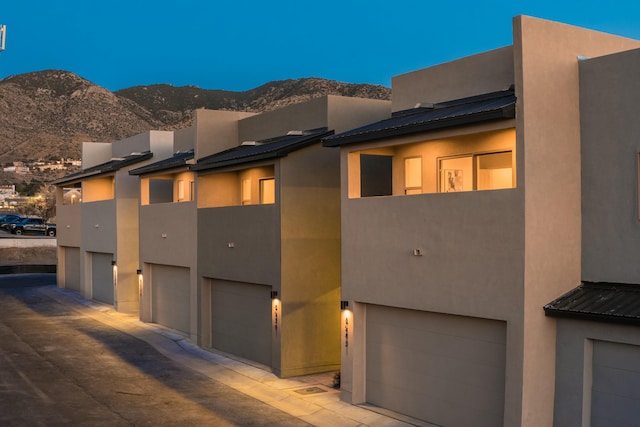 view of front facade featuring a mountain view, metal roof, and stucco siding