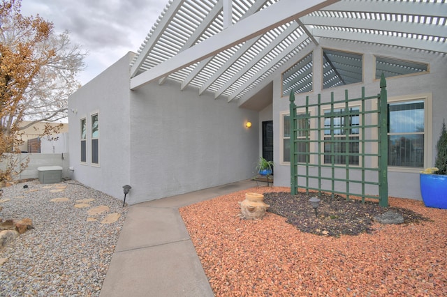 doorway to property with cooling unit and a pergola