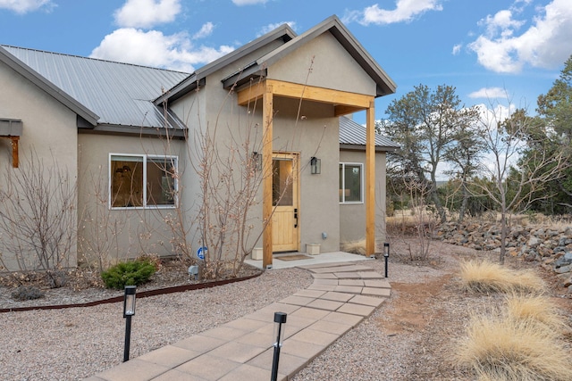 exterior space with metal roof and stucco siding