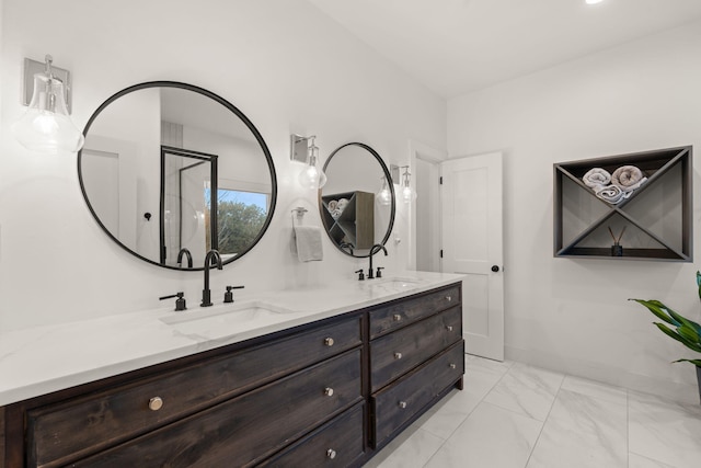 bathroom featuring marble finish floor, double vanity, a sink, and baseboards