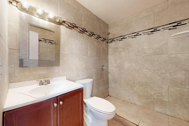 bathroom featuring vanity, tiled shower, and toilet