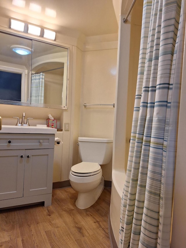 bathroom with vanity, hardwood / wood-style floors, curtained shower, and toilet