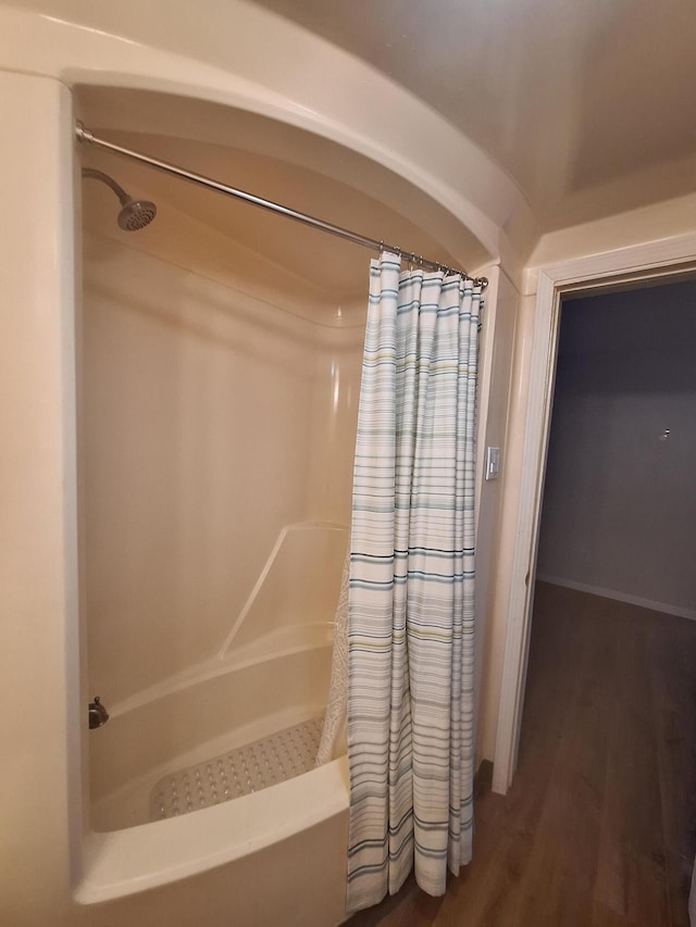 bathroom featuring hardwood / wood-style flooring and shower / tub combo with curtain