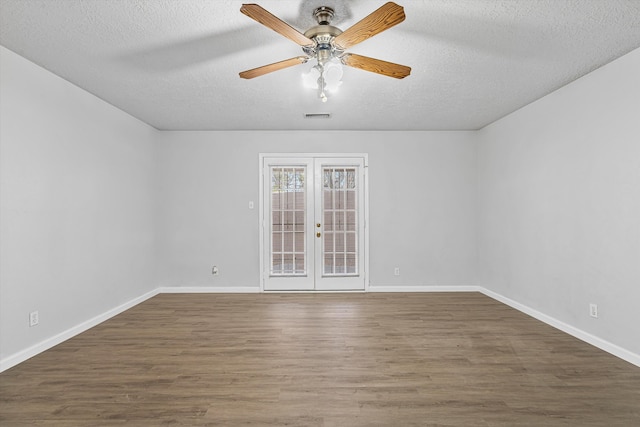 empty room featuring baseboards, visible vents, wood finished floors, and french doors