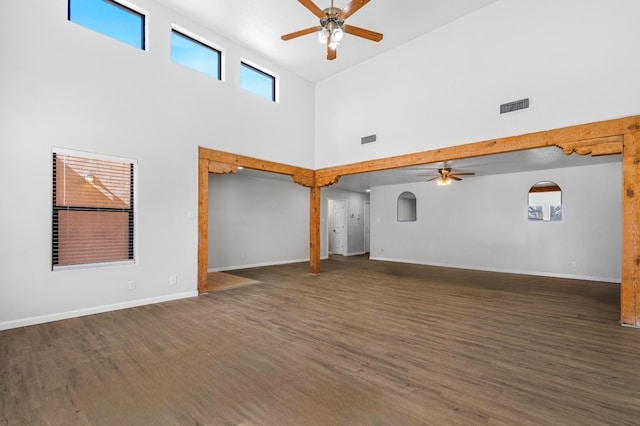 unfurnished living room featuring ceiling fan, wood finished floors, visible vents, and baseboards