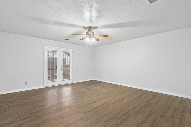 empty room featuring baseboards, visible vents, dark wood finished floors, and french doors